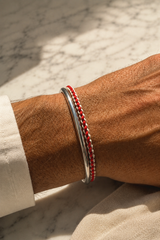 Red and off-white braided organic cotton bracelet with 925 sterling silver clasp styled on the wrist