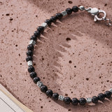Black Onyx Sterling Silver Cube Bracelet with diamond-cut silver cubes styled on a textured stone surface