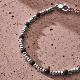 Natural Black Onyx bracelet with 925 sterling silver pebbles styled on a textured surface