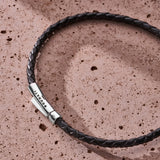 Black braided Italian leather bracelet with 925 sterling silver clasp styled on a stone surface