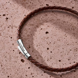 Brown braided Italian leather bracelet with 925 sterling silver clasp styled on a stone surface
