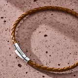 Camel beige braided Italian leather bracelet with 925 sterling silver clasp styled on a stone surface