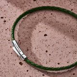 Forest green braided Italian leather bracelet with 925 sterling silver clasp styled on a stone surface