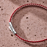 Red and off-white braided organic cotton bracelet with 925 sterling silver clasp styled on the wrist