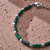 Japanese malachite-style disc bracelet with sterling silver nuggets styled on a textured stone surface