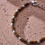 Japanese Tiger Eye-style disc bracelet with sterling silver nuggets styled on a textured surface