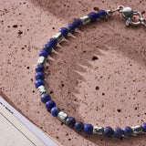 Natural Lapis Lazuli bracelet with 925 sterling silver nuggets styled on a textured surface
