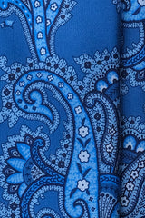 Close-up of blue and navy paisley pattern on Italian printed silk tie.
