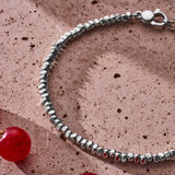 Handmade 925 sterling silver Pebble Bracelet styled on a textured surface