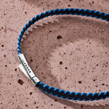 Dark navy and blue stitched Italian textile bracelet with 925 sterling silver clasp styled on a stone surface