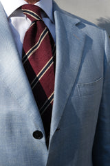Burgundy, beige and navy striped silk shantung tie worn with a blue suit
