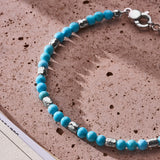 Natural Turquoise bracelet with 925 sterling silver nuggets styled on a textured surface