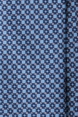 Close-up of the printed silk fabric with light blue, navy and pink butterfly chain motifs.