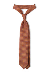 Salmon, orange and light blue butterfly chains printed silk tie, tied in a clean knot.