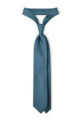 Turquoise, petrol and pink butterfly chains printed silk tie, tied in a clean knot.