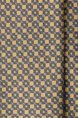 Close-up of the printed silk fabric with vanilla, light blue and white butterfly chain motifs.