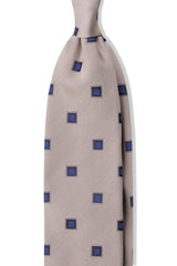 Beige and royal blue geometric square silk jacquard tie, shown from the front.
