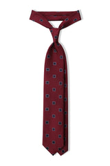 Bordeaux and navy geometric square silk jacquard tie, tied in a clean knot.