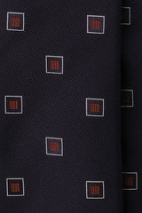 Close-up of the navy and red silk jacquard weave with a geometric square pattern.