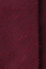 Close-up of the textured burgundy grenadine shantung silk fabric.