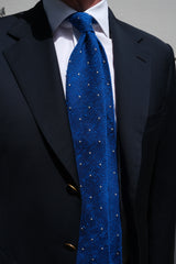 Model wearing the azure blue and white polka dot grenadine shantung silk tie, shown from the front.