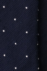 Close-up of the navy grenadine shantung silk texture with white polka dots.