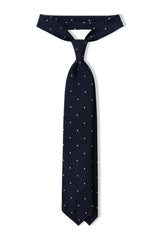 Navy and white polka dot grenadine shantung silk tie, tied in a knot.