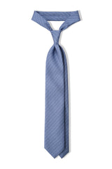 Light blue, navy and white stirrup chain printed silk tie, tied in a clean knot.