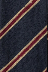 Close-up of navy, beige and burgundy striped silk shantung fabric texture.