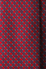 Close-up of the printed silk fabric with red, light blue and white butterfly chain motifs.