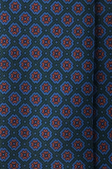 Close-up of the screen-printed Ancient Madder silk with a forest, blue and orange floral pattern.