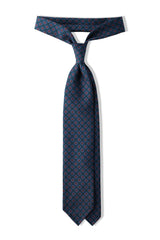 Forest, blue and orange floral Ancient Madder silk tie, tied in a knot.