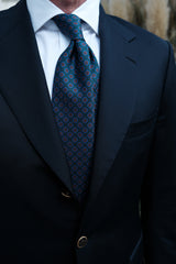 Model wearing the forest, blue and orange floral Ancient Madder silk tie.
