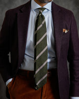 Model wearing the green and white grenadine shantung silk tie as part of a classic outfit.