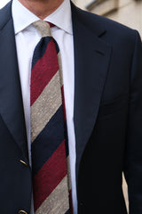 Model styling the burgundy, navy and beige striped grenadine shantung silk tie with tailored clothing.