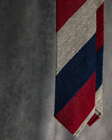 Burgundy, navy and beige striped grenadine shantung silk tie shown in a styled mood image.