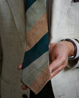 Model wearing the green, beige and mustard striped grenadine shantung silk tie in a tailored look.