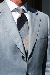 Model styling the navy, white and light blue striped grenadine shantung silk tie with tailored clothing.