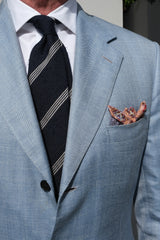 Model styling the navy and white striped grenadine shantung silk tie with tailored clothing.