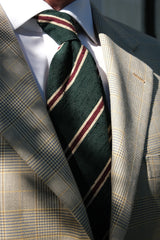 Model styling the forest, beige and burgundy striped silk shantung tie with tailored clothing.